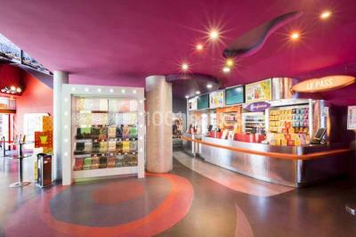 Miniature Location salle Nantes (Loire-Atlantique) - Pathé Nantes #3 Salle de cinéma vide avec des rangées de sièges rouges, un écran blanc et un plafond décoré d'étoiles.