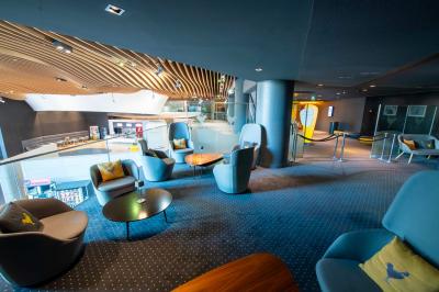 Salle de cinéma IMAX avec 520 fauteuils rouges, écran géant et éclairage tamisé.