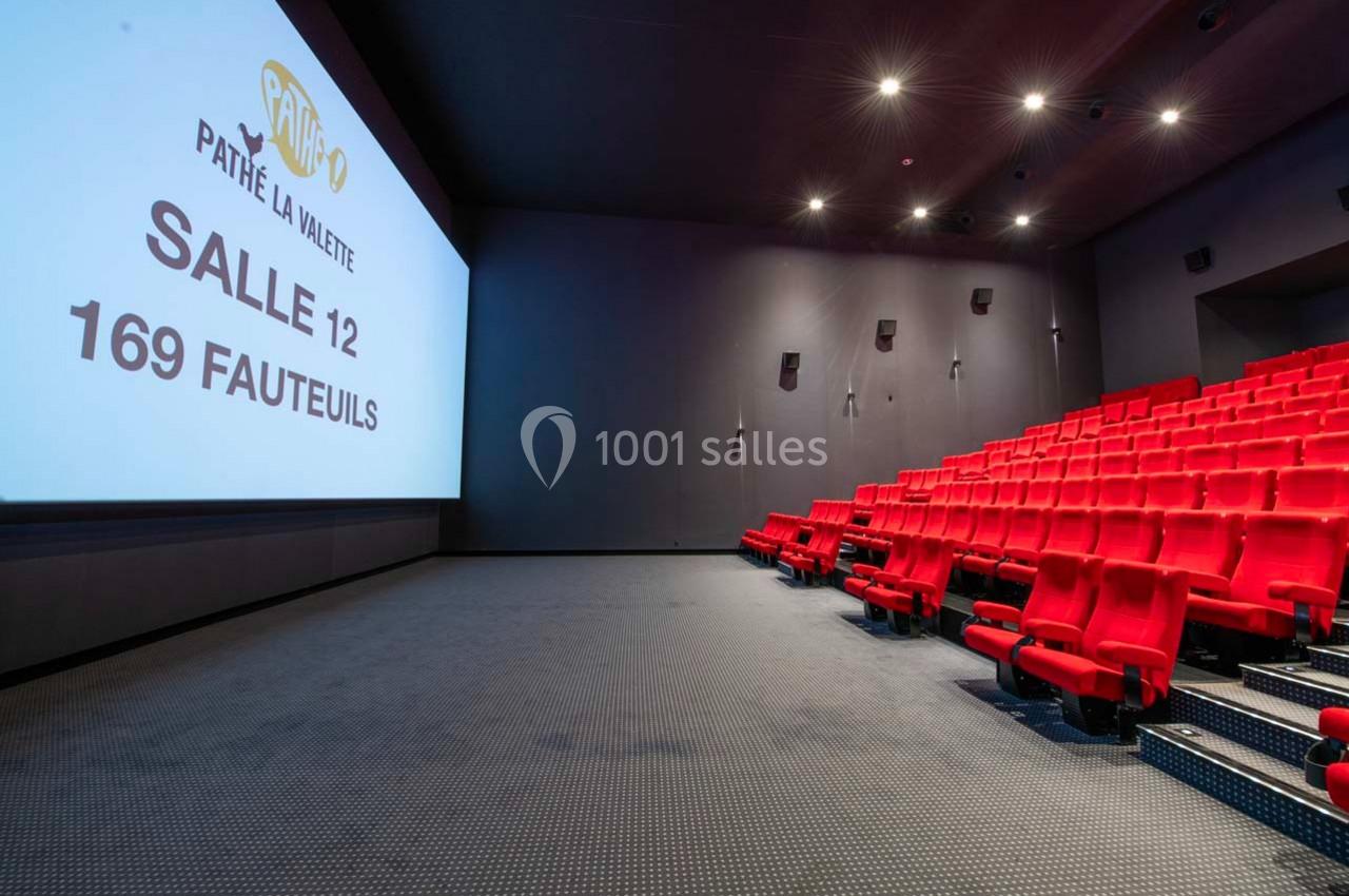 Salle de cinéma avec écran affichant ’Pathé La Valette, Salle 12, 169 fauteuils’, rangées de sièges rouges vides.