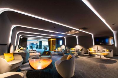 Salle de cinéma IMAX avec 520 fauteuils rouges, écran géant et éclairage tamisé.