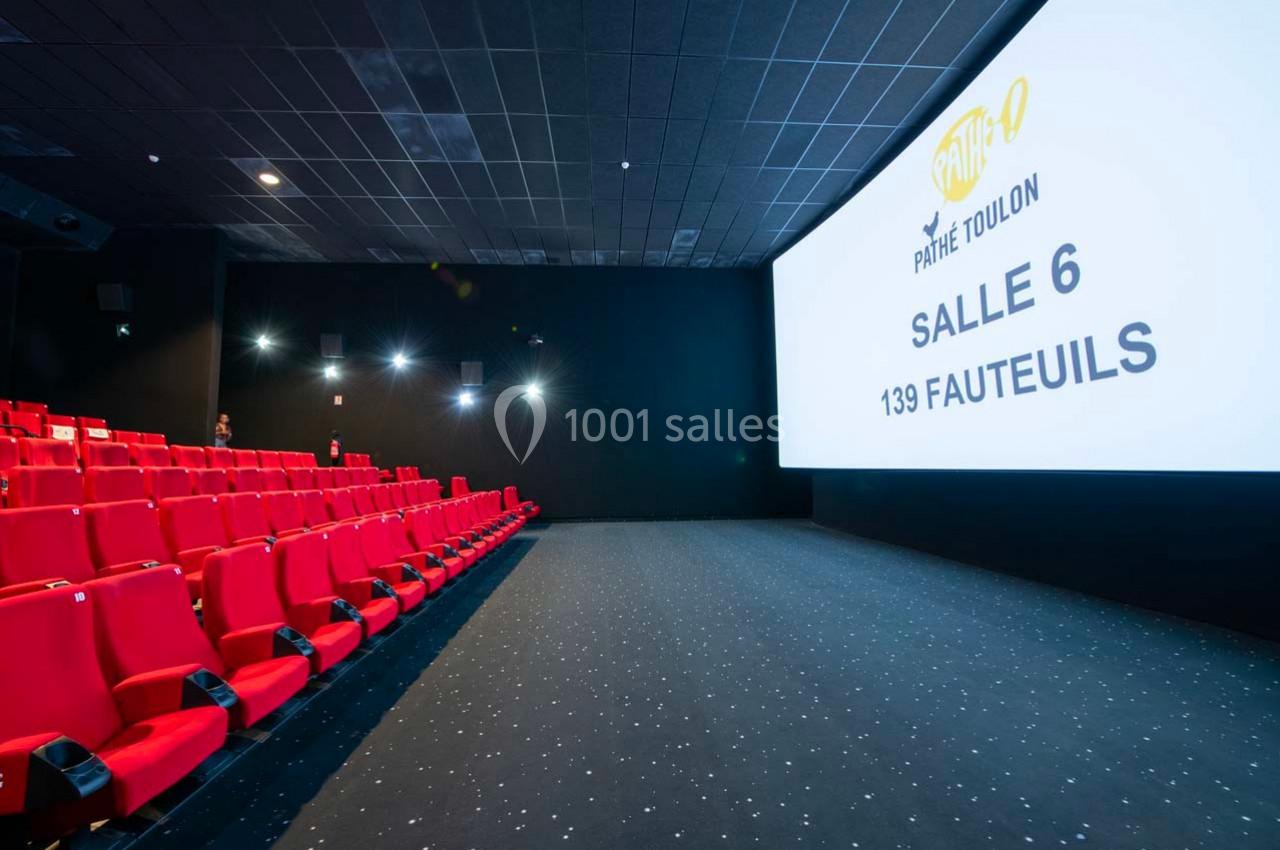 Salle de cinéma avec rangées de sièges rouges, écran affichant ’Pathé Toulon, Salle 6, 139 fauteuils’.