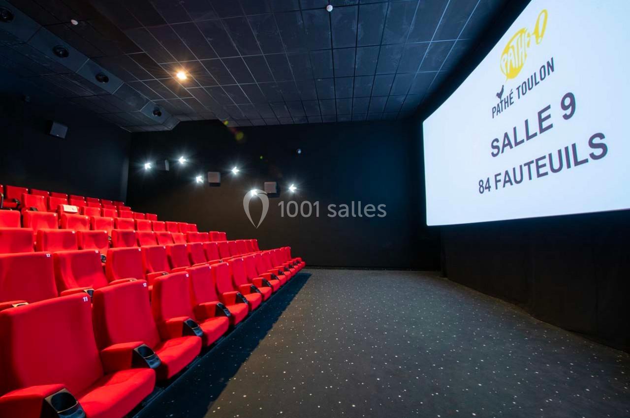Salle de cinéma avec rangées de sièges rouges et écran affichant ’Pathé Toulon Salle 9, 84 fauteuils’.