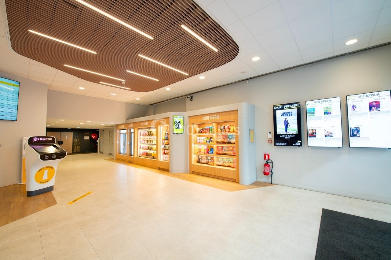Hall lumineux avec présentoirs de produits, écrans d'affichage numérique, borne interactive et plafond en bois.