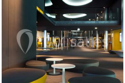 Bâtiment moderne avec façade jaune et noire, grandes baies vitrées et enseigne indiquant ’La Salle Parc’.