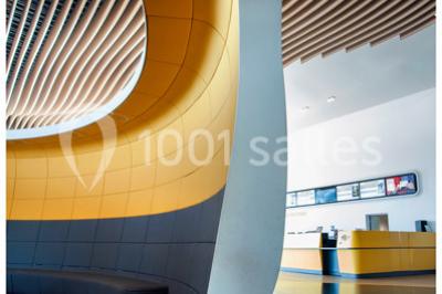 Bâtiment moderne avec façade jaune et noire, grandes baies vitrées et enseigne indiquant ’La Salle Parc’.