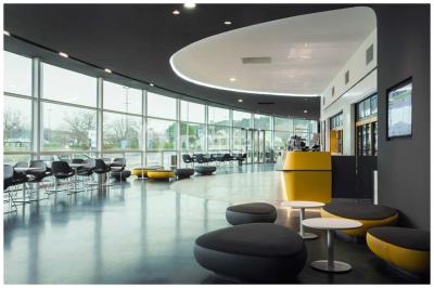 Bâtiment moderne avec façade jaune et noire, grandes baies vitrées et enseigne indiquant ’La Salle Parc’.