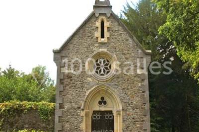 Statue blanche en forme de figure humaine tenant une vasque d'où s'écoule de l'eau, entourée de végétation.