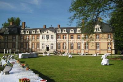 Chambre lumineuse avec lit double, bureau en bois, lampes allumées et rideaux à carreaux devant des fenêtres.