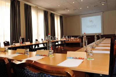 Lit double avec oreillers et coussins jaunes, éclairé par des lampes dorées, devant un mur décoré de motifs artistiques.