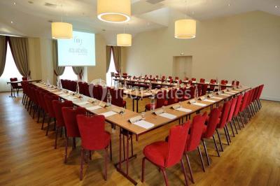 Lit double avec oreillers et coussins jaunes, éclairé par des lampes dorées, devant un mur décoré de motifs artistiques.