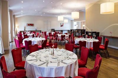 Lit double avec oreillers et coussins jaunes, éclairé par des lampes dorées, devant un mur décoré de motifs artistiques.