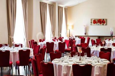 Lit double avec oreillers et coussins jaunes, éclairé par des lampes dorées, devant un mur décoré de motifs artistiques.