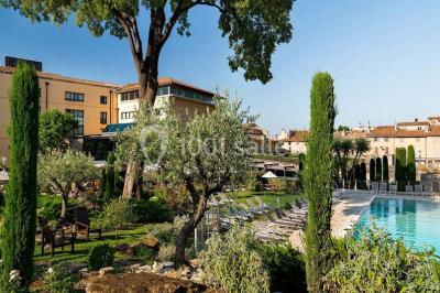Lit double avec oreillers et coussins jaunes, éclairé par des lampes dorées, devant un mur décoré de motifs artistiques.