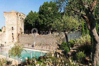 Lit double avec oreillers et coussins jaunes, éclairé par des lampes dorées, devant un mur décoré de motifs artistiques.