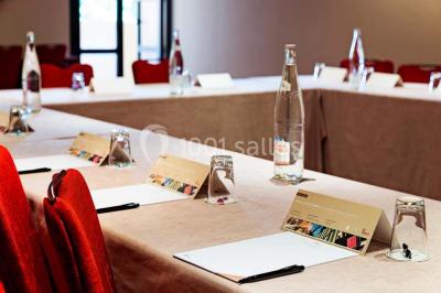 Lit double avec oreillers et coussins jaunes, éclairé par des lampes dorées, devant un mur décoré de motifs artistiques.