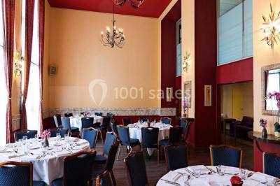 Lit double avec oreillers et coussins jaunes, éclairé par des lampes dorées, devant un mur décoré de motifs artistiques.