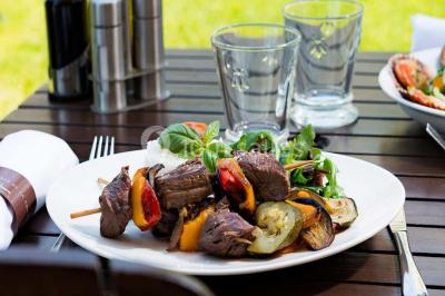 Lit double avec oreillers et coussins jaunes, éclairé par des lampes dorées, devant un mur décoré de motifs artistiques.