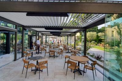 Lit double avec oreillers et coussins jaunes, éclairé par des lampes dorées, devant un mur décoré de motifs artistiques.