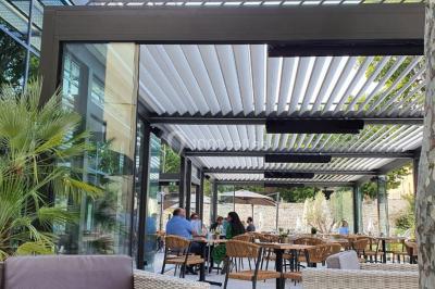 Lit double avec oreillers et coussins jaunes, éclairé par des lampes dorées, devant un mur décoré de motifs artistiques.