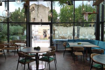 Lit double avec oreillers et coussins jaunes, éclairé par des lampes dorées, devant un mur décoré de motifs artistiques.