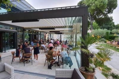 Lit double avec oreillers et coussins jaunes, éclairé par des lampes dorées, devant un mur décoré de motifs artistiques.