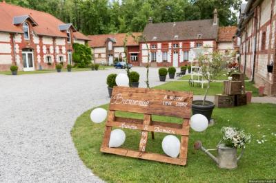 Panneau en métal avec l'inscription ’La Ferme Blanche’, reflétant la lumière du soleil couchant.
