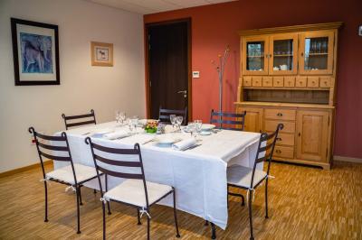 Un hall moderne avec des murs bleus, des fauteuils bleus, une table basse en verre et des œuvres d'art accrochées.