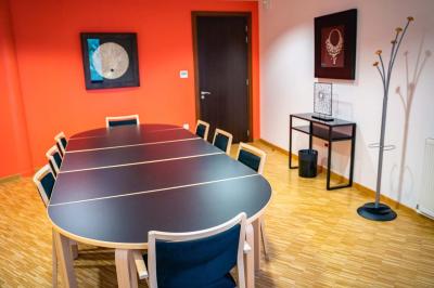 Un hall moderne avec des murs bleus, des fauteuils bleus, une table basse en verre et des œuvres d'art accrochées.