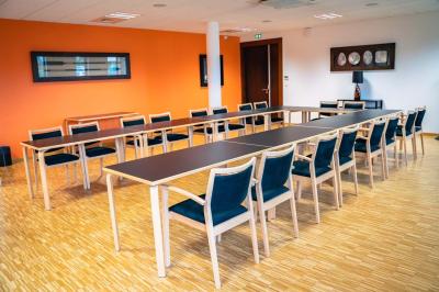 Un hall moderne avec des murs bleus, des fauteuils bleus, une table basse en verre et des œuvres d'art accrochées.