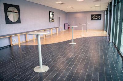 Un hall moderne avec des murs bleus, des fauteuils bleus, une table basse en verre et des œuvres d'art accrochées.