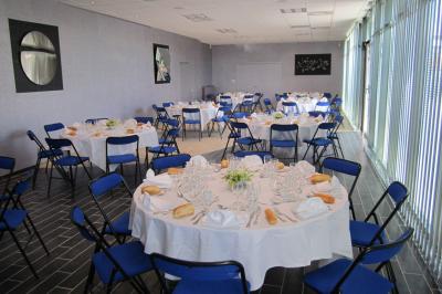 Un hall moderne avec des murs bleus, des fauteuils bleus, une table basse en verre et des œuvres d'art accrochées.