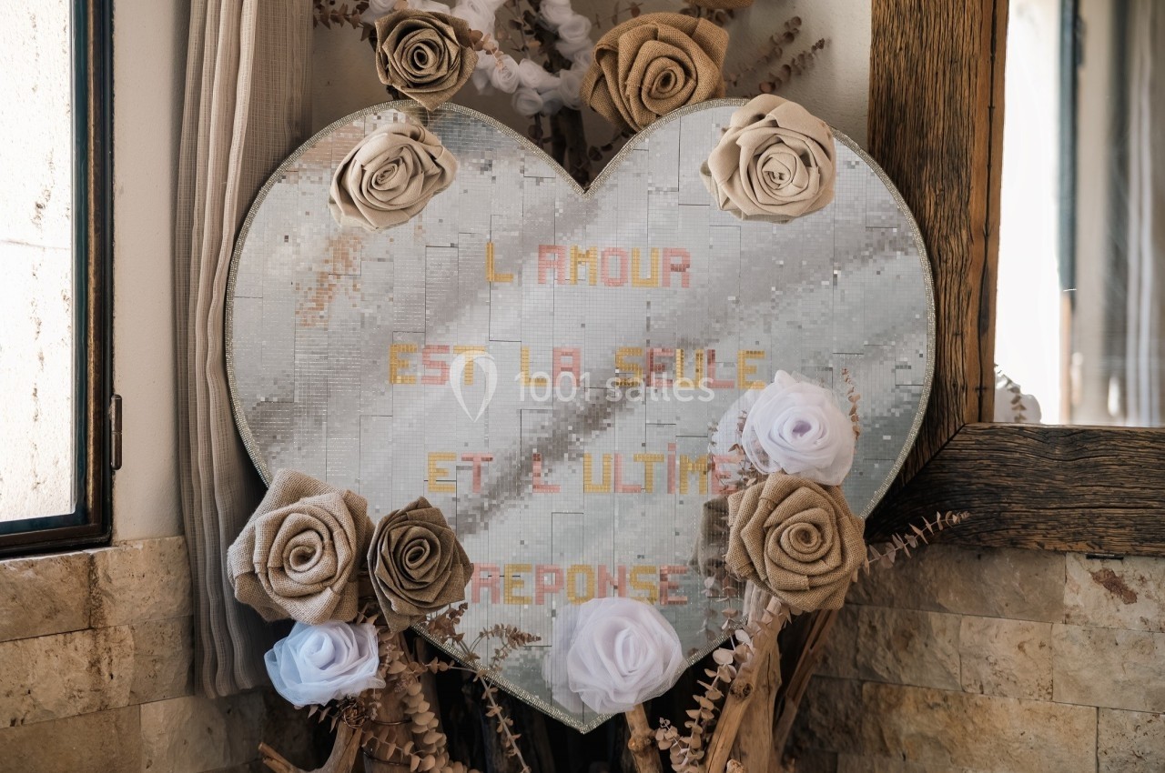 Cœur décoratif en mosaïque avec des roses en tissu, portant l'inscription ’L'amour est la seule et l'ultime réponse’.