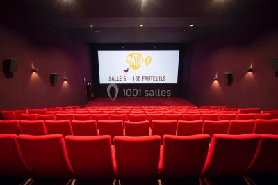 Espace intérieur spacieux avec moquette rouge, colonnes, éclairage tamisé et fauteuils disposés près des vitrines.