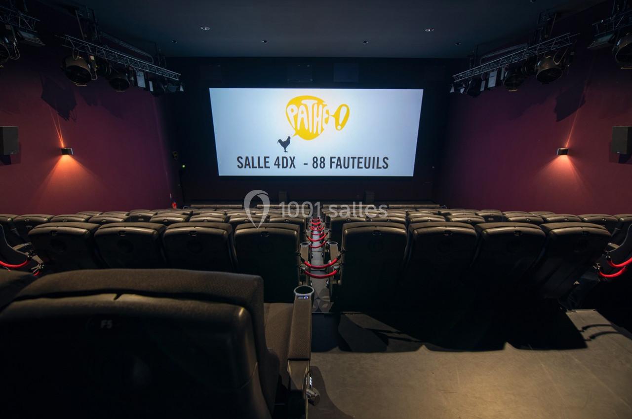 Salle de cinéma vide avec écran affichant ’Pathé - Salle 4DX - 88 fauteuils’, rangées de sièges au premier plan.