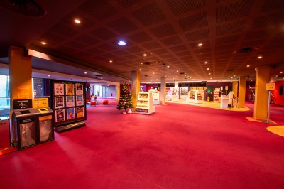 Rangée de fauteuils rouges numérotés dans une salle de cinéma sombre.