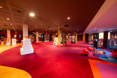 Rangée de fauteuils rouges numérotés dans une salle de cinéma sombre.