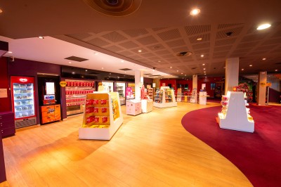Rangée de fauteuils rouges numérotés dans une salle de cinéma sombre.