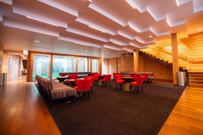 Silhouette d'un coq noir sur une rambarde en bois devant un mur blanc avec le logo jaune ’Pathé !’ éclairé par la lumière.