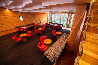 Silhouette d'un coq noir sur une rambarde en bois devant un mur blanc avec le logo jaune ’Pathé !’ éclairé par la lumière.