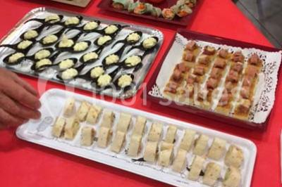 Bâtiment moderne à deux étages avec façade grise et rouge, entouré d'un parking et clôturé par une grille noire.