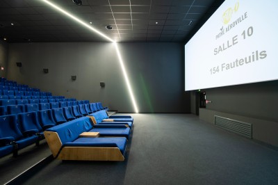 Façade d'un cinéma Pathé avec enseignes lumineuses, affiches de films et entrée principale visible.