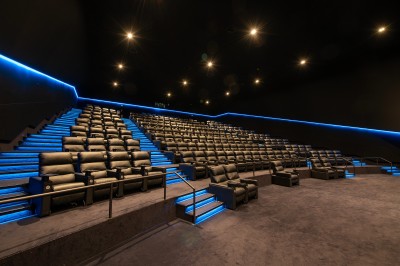 Façade d'un cinéma Pathé avec enseignes lumineuses, affiches de films et entrée principale visible.