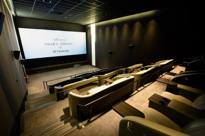 Façade d'un cinéma Pathé avec enseignes lumineuses, affiches de films et entrée principale visible.