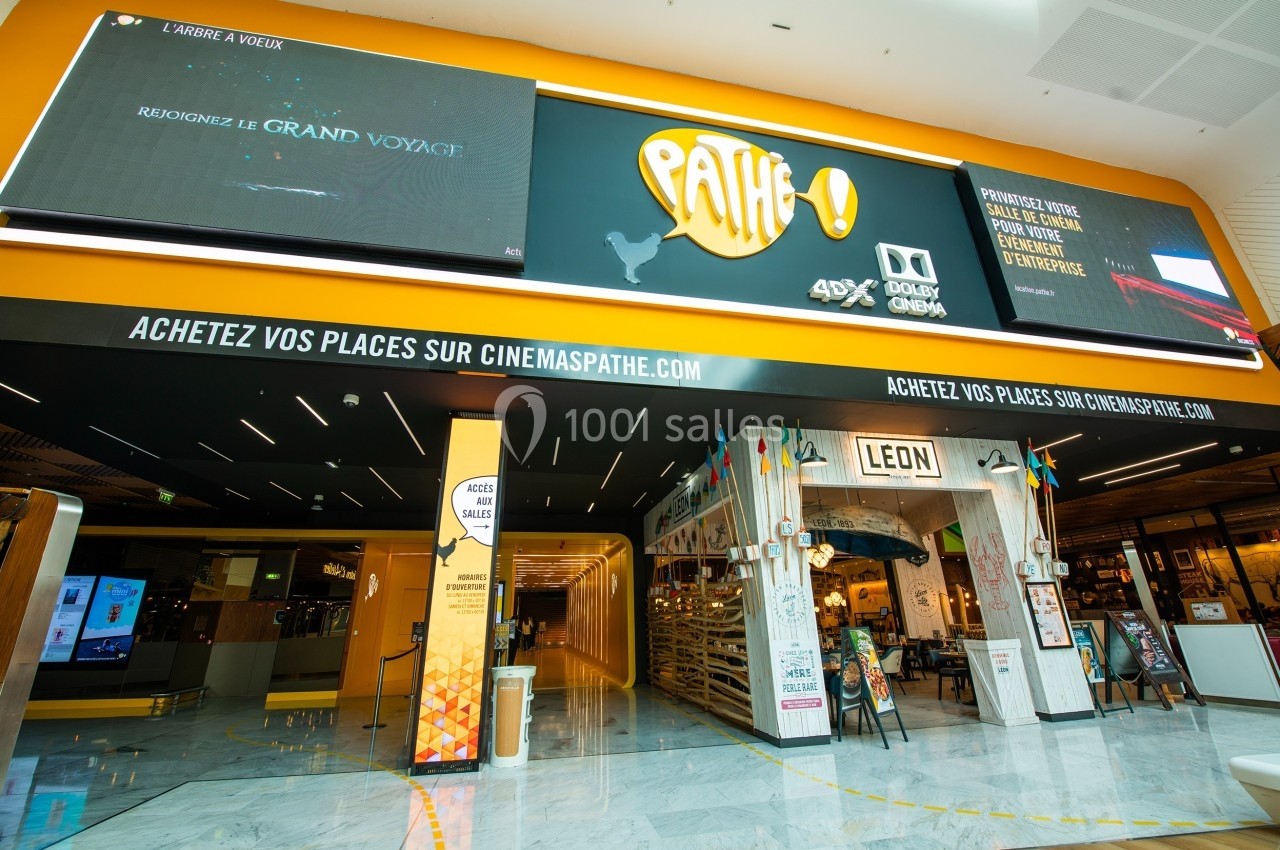 Façade d'un cinéma Pathé avec enseignes lumineuses, affiches de films et entrée principale visible.
