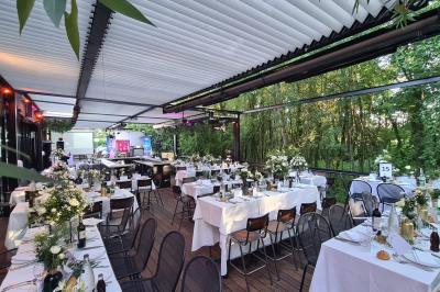 Salle de restaurant moderne avec chaises colorées, tables dressées et éclairage tamisé.