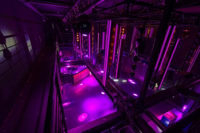 Salle de toilettes modernes avec lavabos en acier inoxydable, miroirs, cabines fermées et éclairage au plafond.