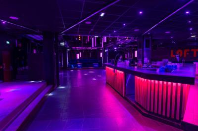 Salle de toilettes modernes avec lavabos en acier inoxydable, miroirs, cabines fermées et éclairage au plafond.