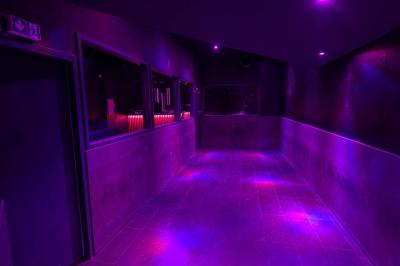 Salle de toilettes modernes avec lavabos en acier inoxydable, miroirs, cabines fermées et éclairage au plafond.