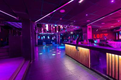 Salle de toilettes modernes avec lavabos en acier inoxydable, miroirs, cabines fermées et éclairage au plafond.