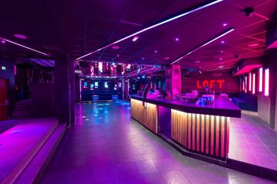 Salle de toilettes modernes avec lavabos en acier inoxydable, miroirs, cabines fermées et éclairage au plafond.